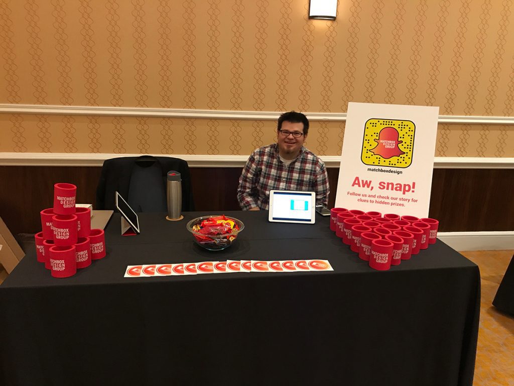 Cullen sitting behind the table at the career fair during MDMC17 otherwise known as the Midwest Digital Marketing Conference.