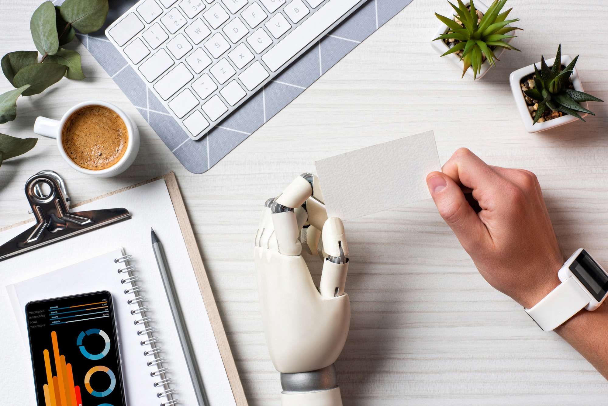 Business card being held by robot and human hand.