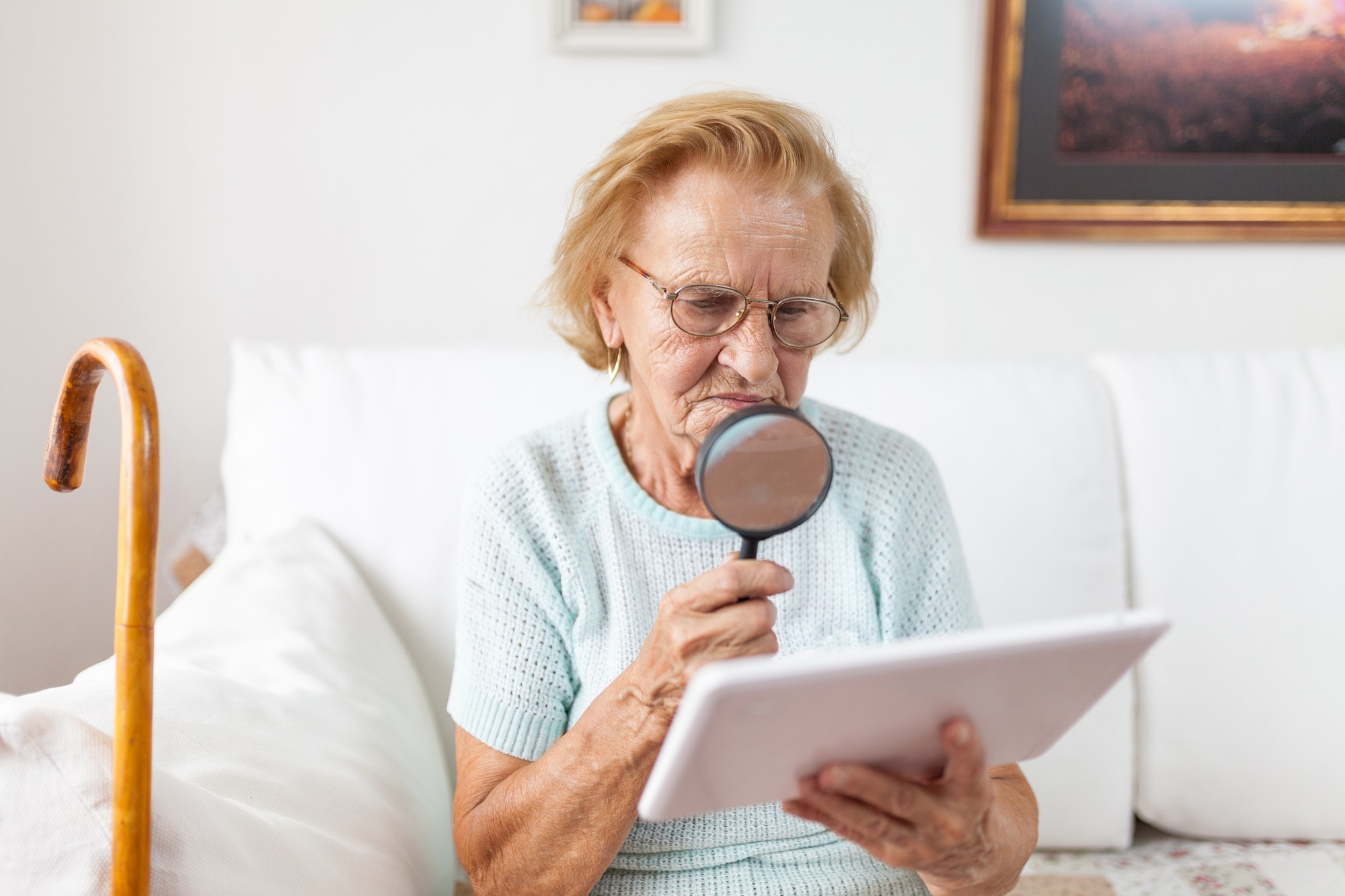 Elderly woman with glasses. A transcript that can be read could help her.