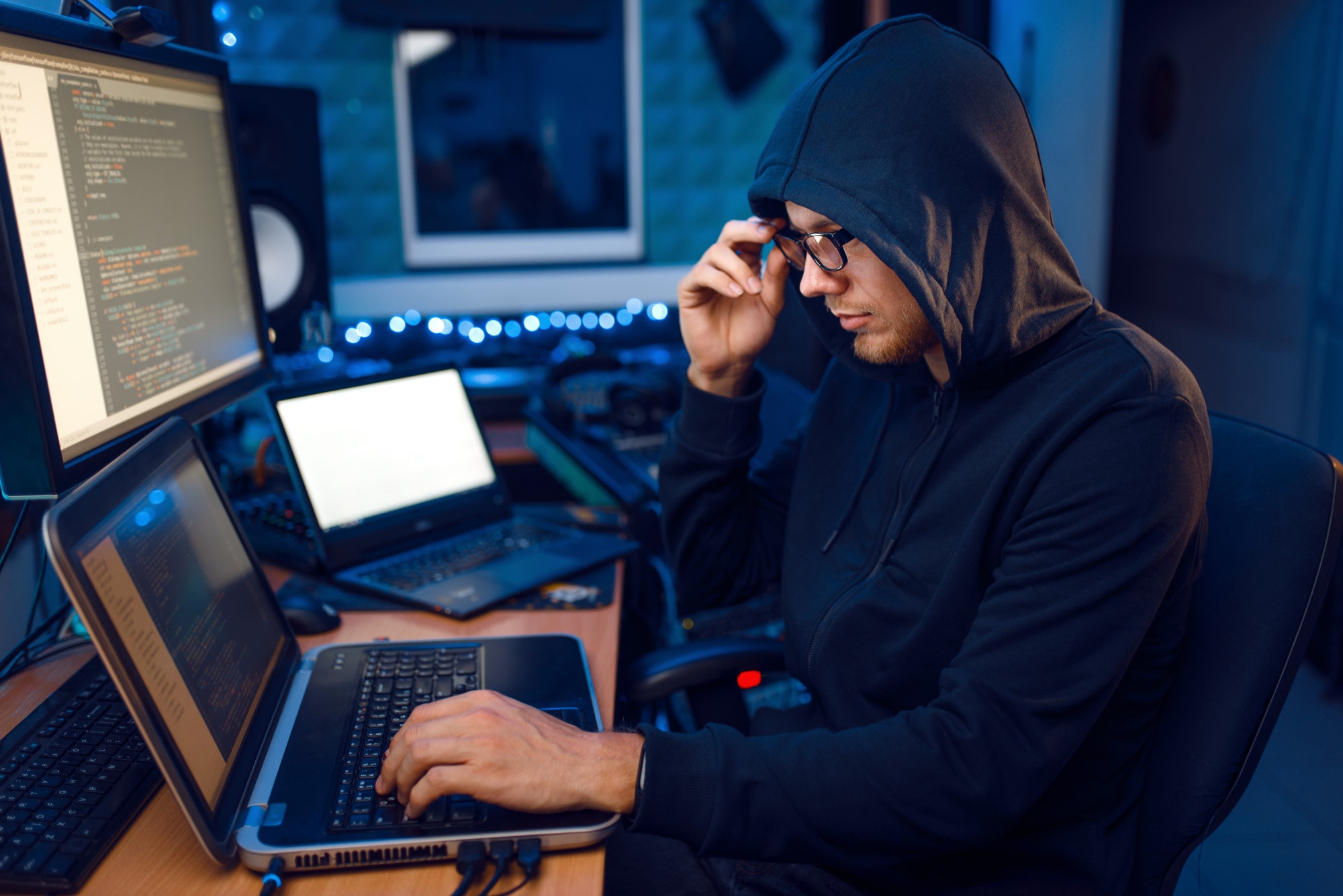 Hacker in hood at his workplace. The Impact Of Blockchain will improve security.