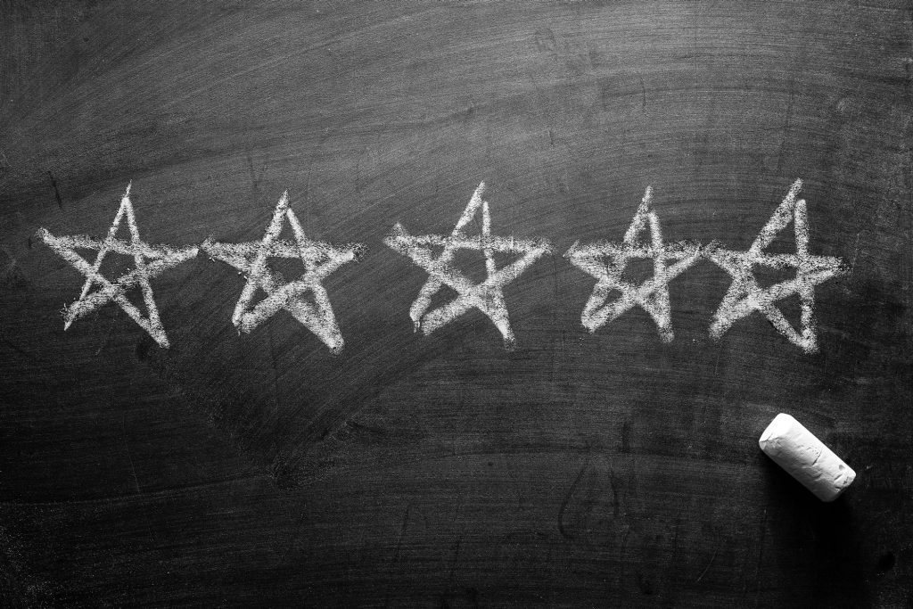 Line of five star clutch reviews hand drawn on a blackboard.