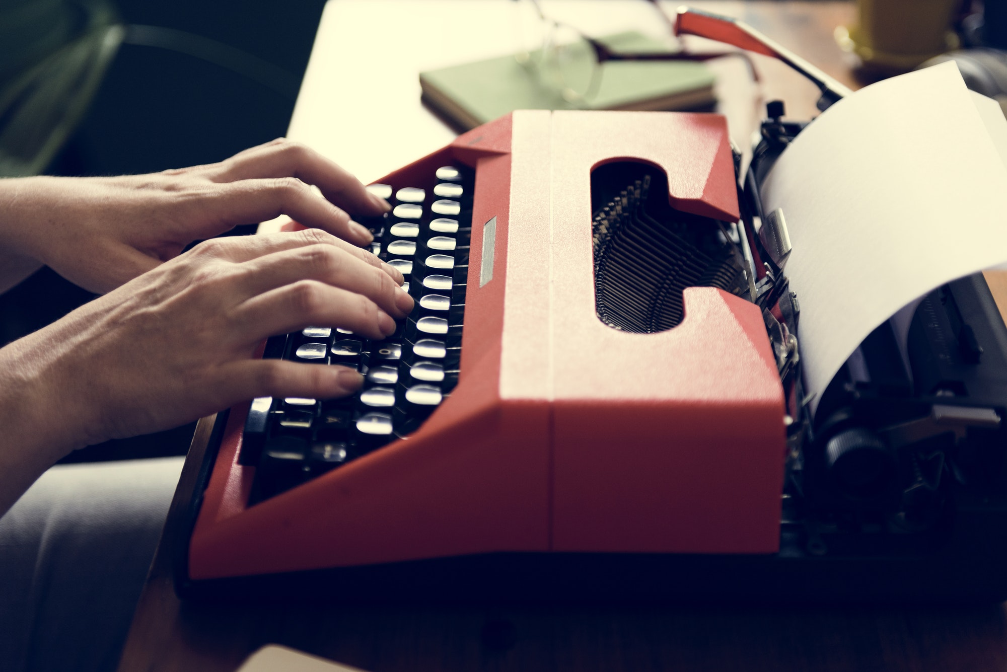 Woman typing on a retro typewriter creating content