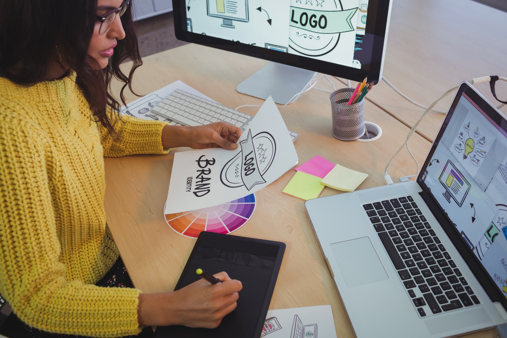 Young graphic designer working at office desk.