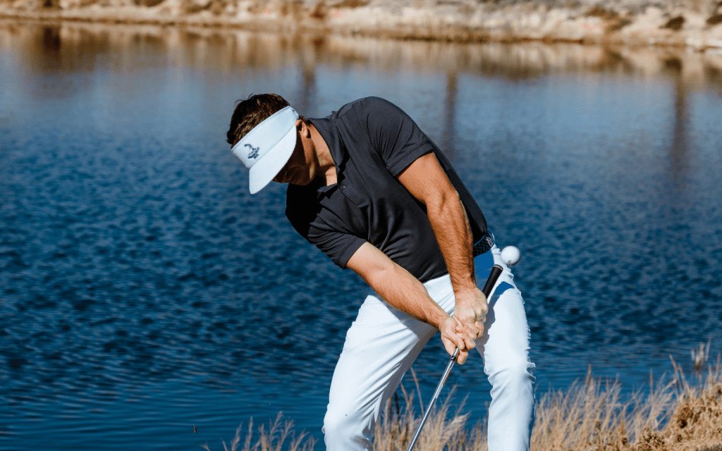 Golfer wearing Imperial Sports gear hitting out of trouble.