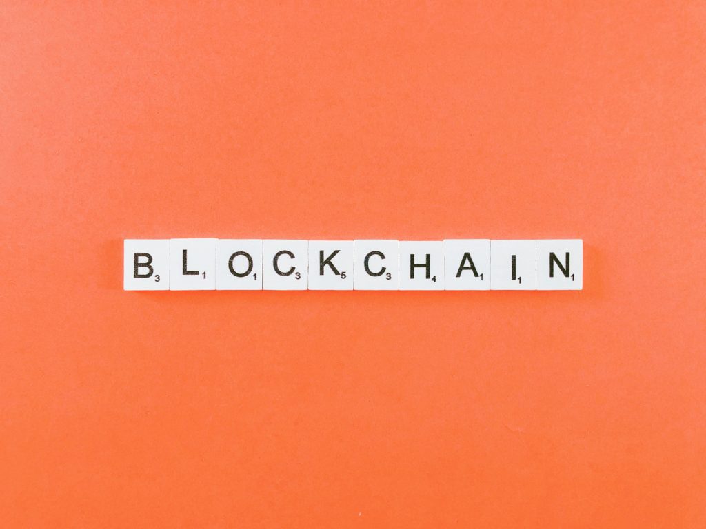 Blockchain in letter blocks with orange background.