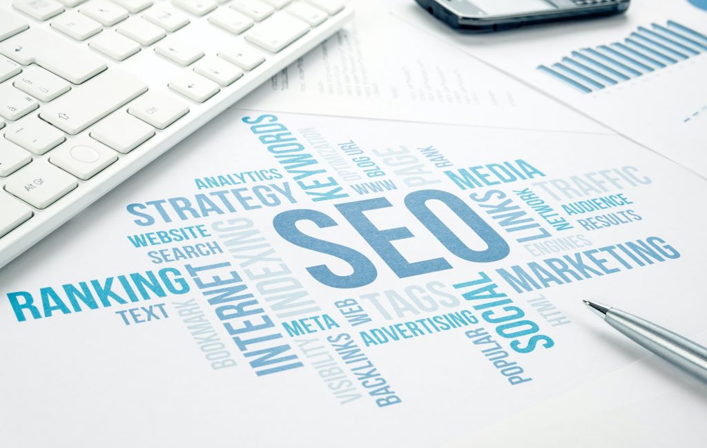 SEO Friendly Website: How To Design It? SEO words on paper.