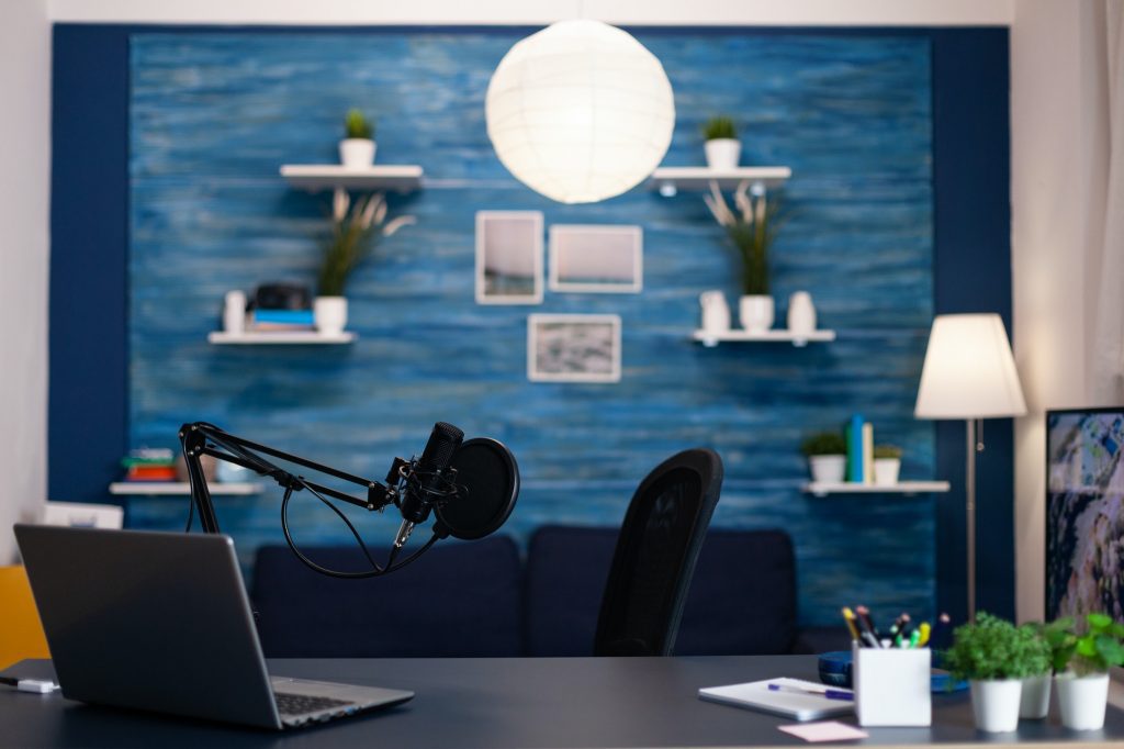 Empty podcast studio with nobody in it equipped with professional production podcasting equipment.