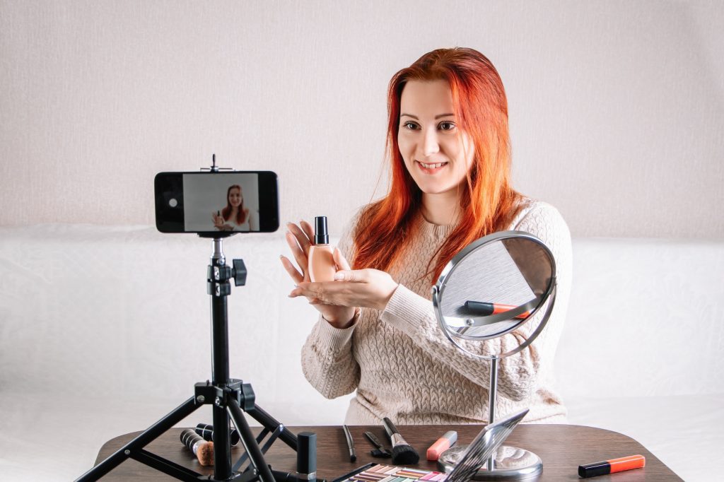 Woman beauty blogger records video content on her smartphone for your vlog. Modern influencer