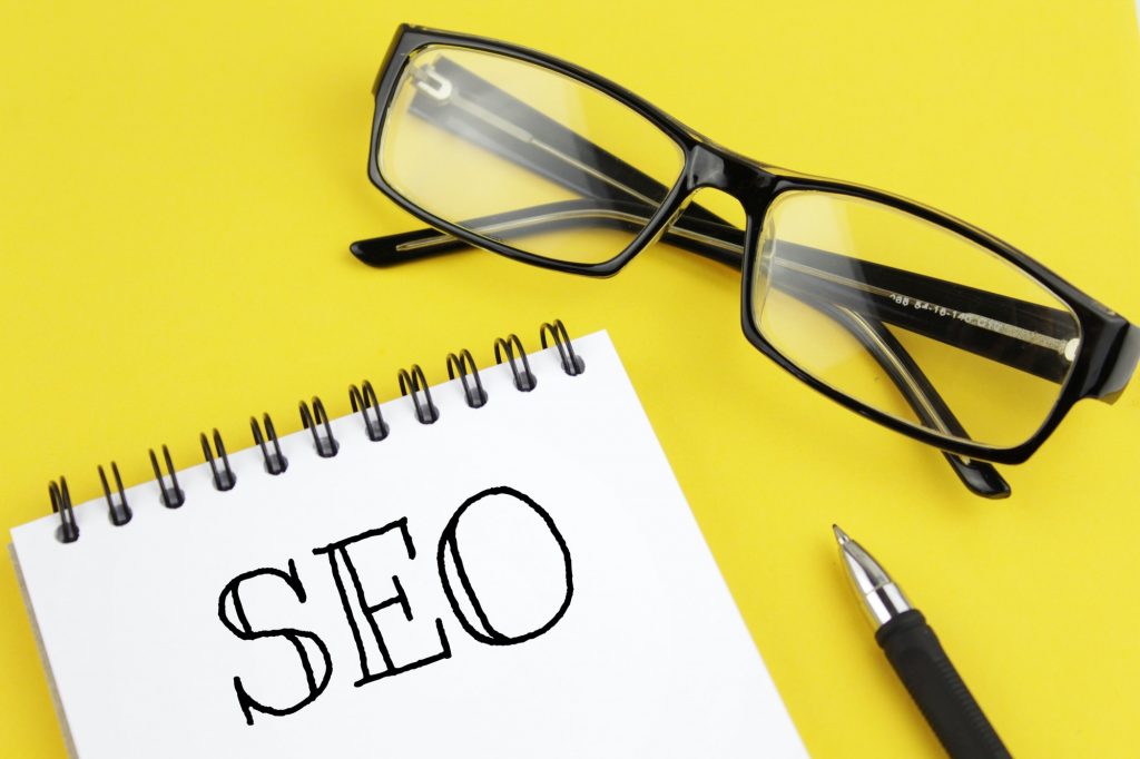 7 Latest SEO Techniques Of 2022 To Increase Organic Traffic | St. Louis SEO Agency Blank paper with inscription SEO on a yellow background.