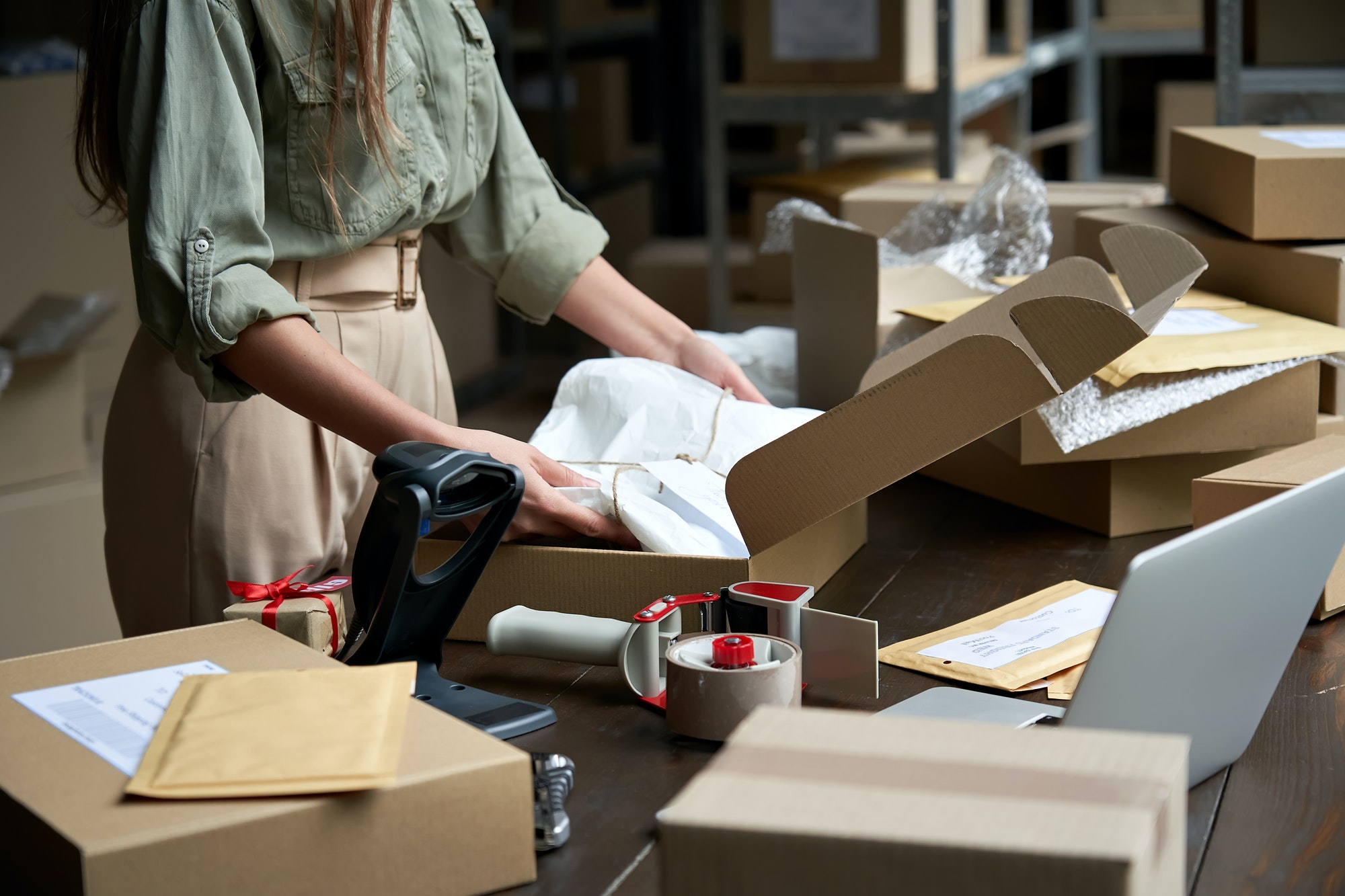 Female online store business owner packing eCommerce packages.