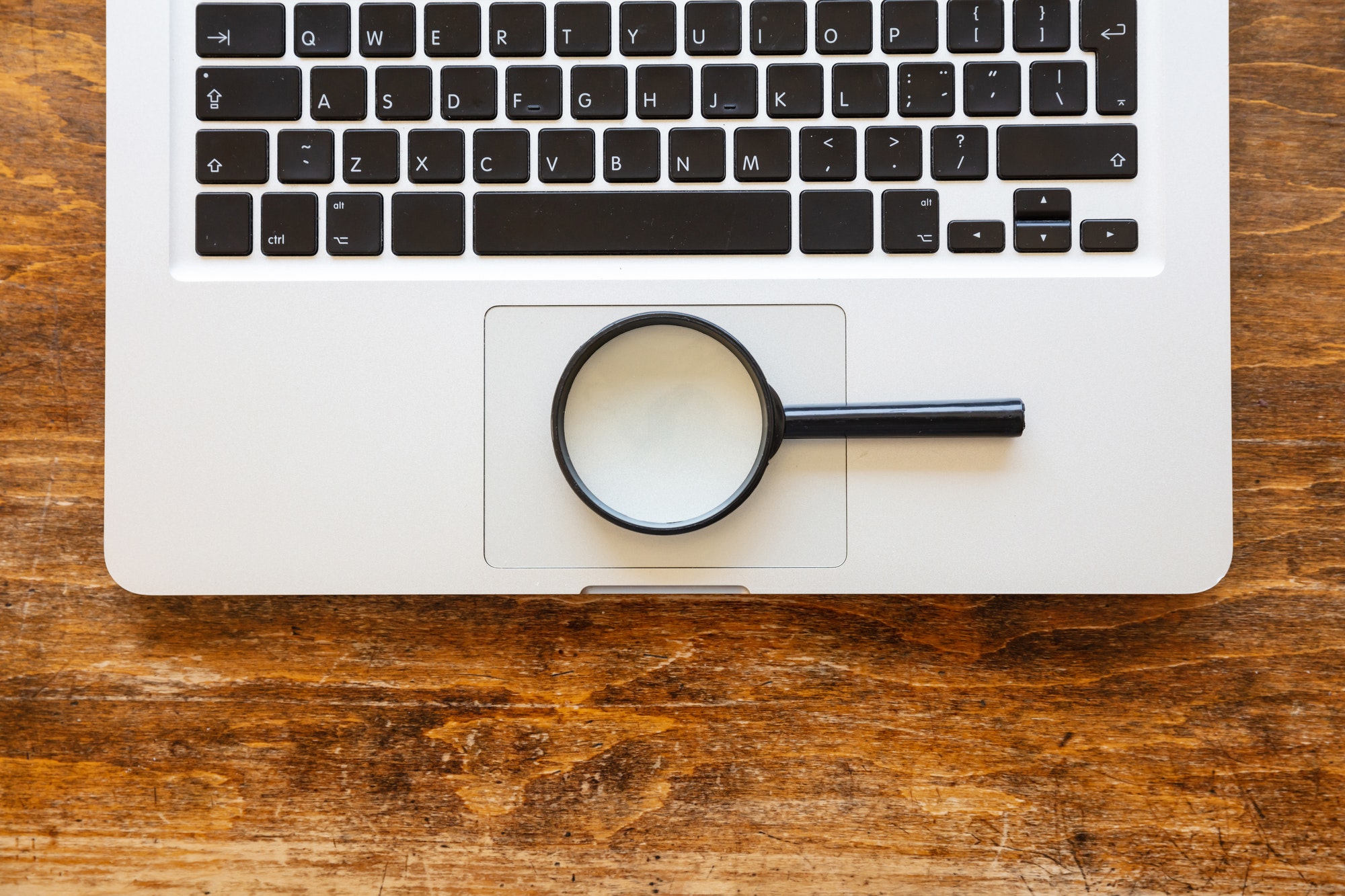 Magnifying glass on a computer laptop. Check Domain Authority.