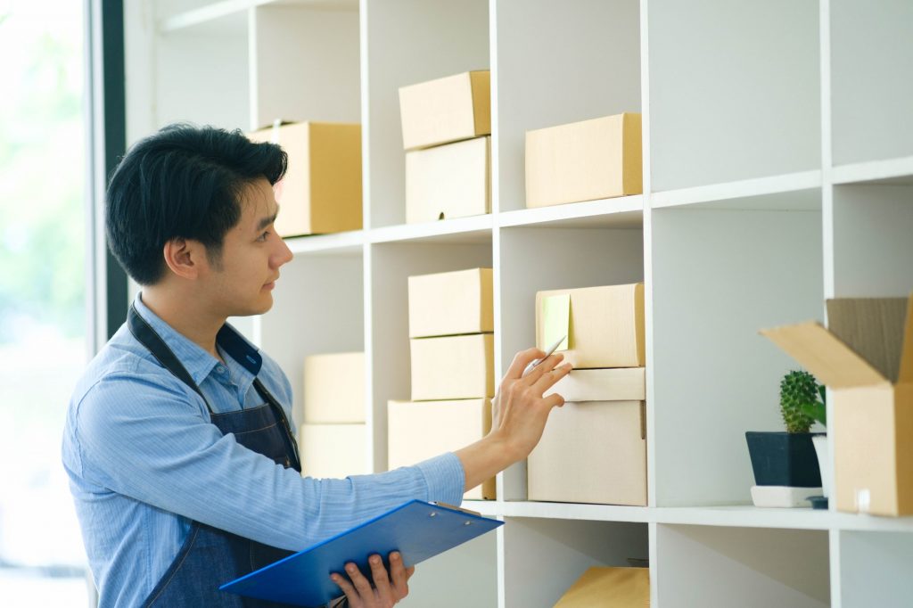 Young businessman checking inventory in small business.