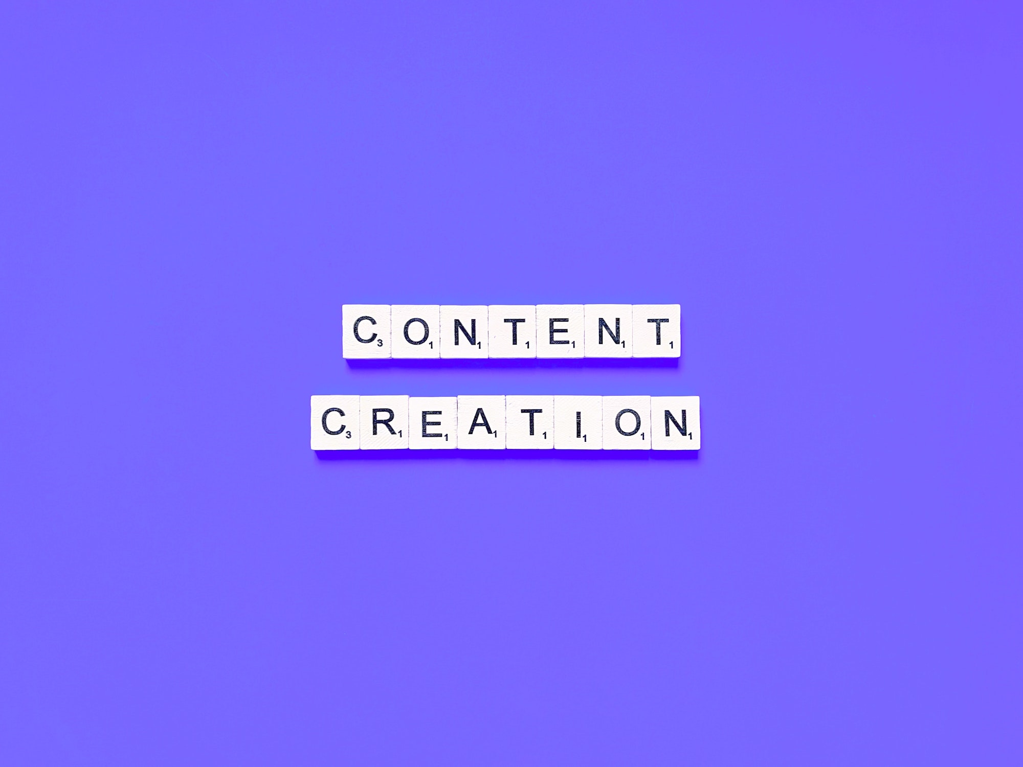 Content creation written on scrabble letters with a purple background.