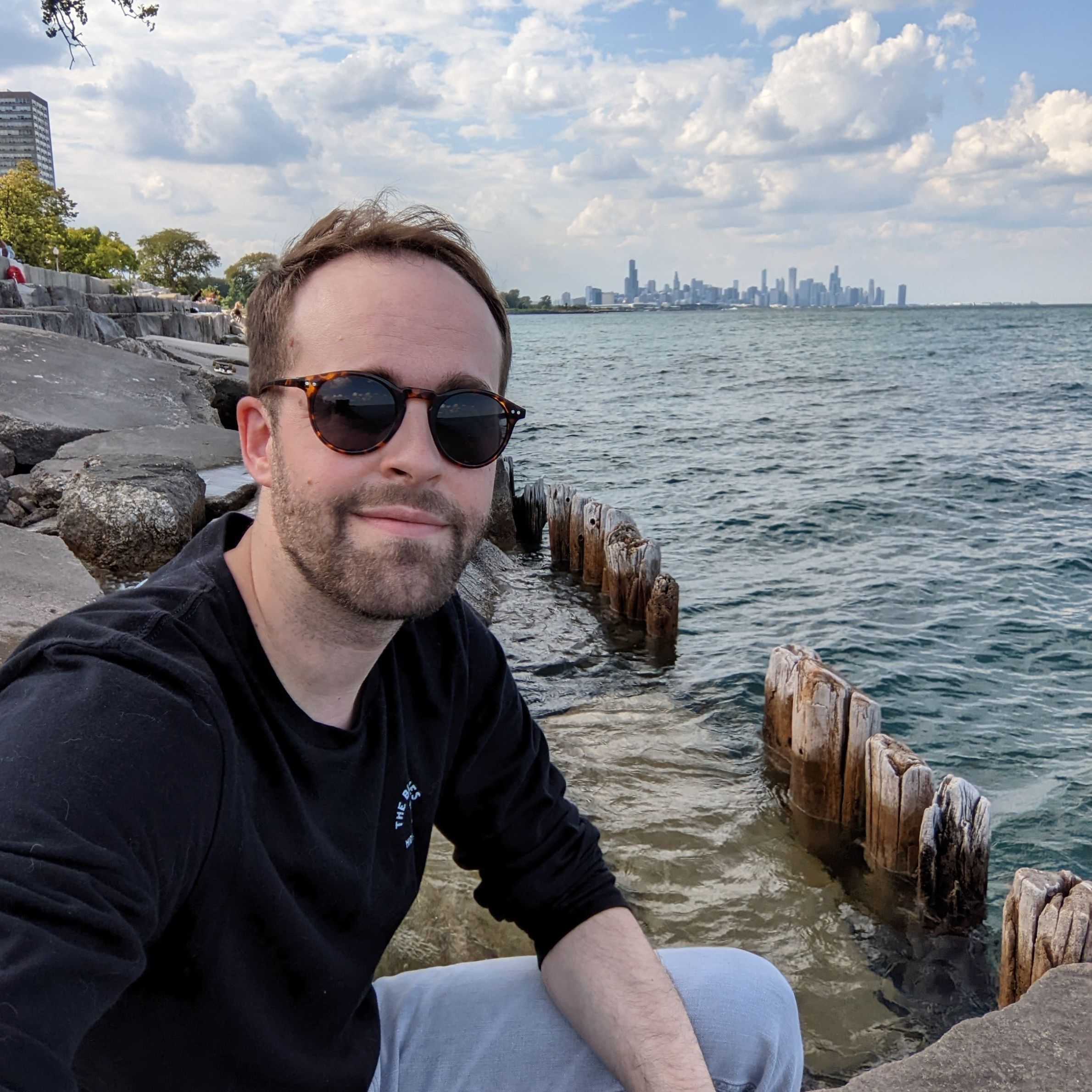 Keegan Dechant selfie by the shoreline of lake Michigan with the Chicago skyline in the background