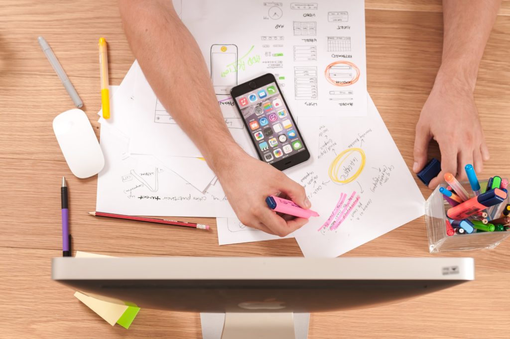 a desk with drawings and a computer