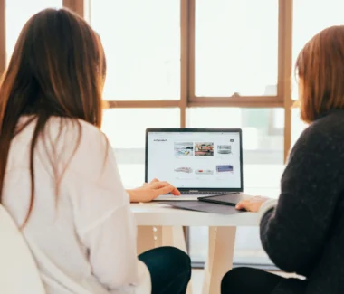 Two women looking at an ecommerce store on a laptop