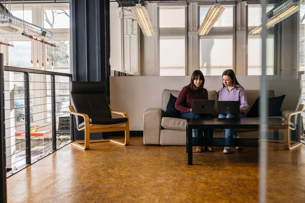 Two Matchbox Design Group employees working on their laptops at the Matchbox office